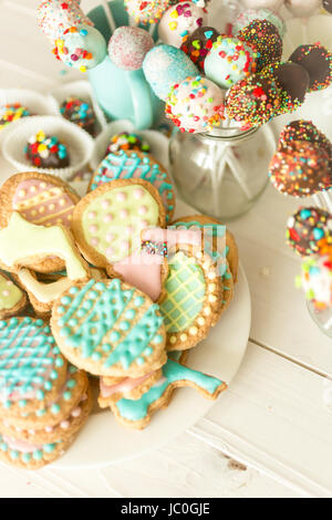 Variété de cake pops colorés et les cookies sur un bureau en bois blanc Banque D'Images