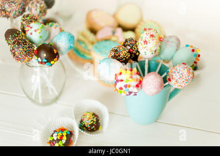 Libre de droit de cake pops colorés dans cups sur un bureau en bois blanc Banque D'Images