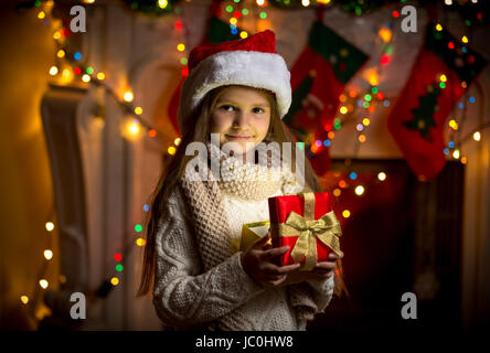 Closeup portrait of smiling girl opening gift box mousseux à Noël Banque D'Images