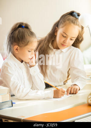 Closeup portrait de sœur aînée aide aux devoirs de plus jeune Banque D'Images