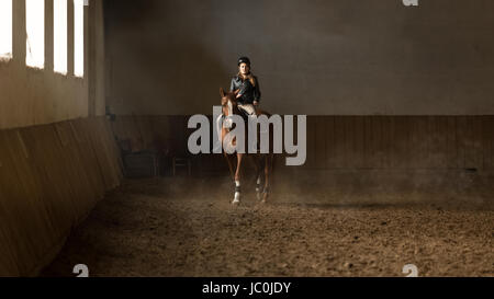 Belle jeune femme jockey formation au manège Banque D'Images