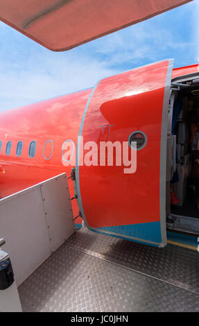 Photo de porte ouverte de gros avion civil peint en rouge Banque D'Images