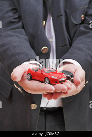 Voiture rouge et clé en main du vendeur close up Banque D'Images