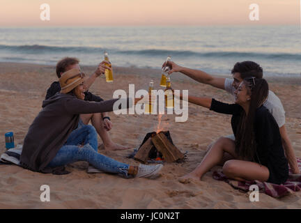 Les amis sur la plage partie boire de l'alcool et les verres clink Banque D'Images