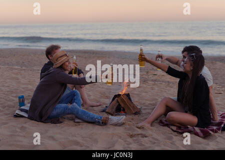 Les amis sur la plage partie boire de l'alcool et les verres clink Banque D'Images