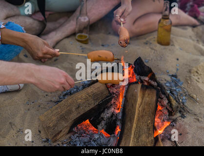 Amis assis sur la plage. l'homme est de jouer de la guitare. Banque D'Images