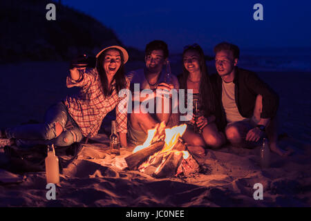 Riends assis sur la plage et prendre des selfies Banque D'Images