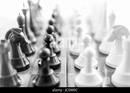 Noir et blanc photo gros plan des pièces d'échecs debout en rangées face à face Banque D'Images