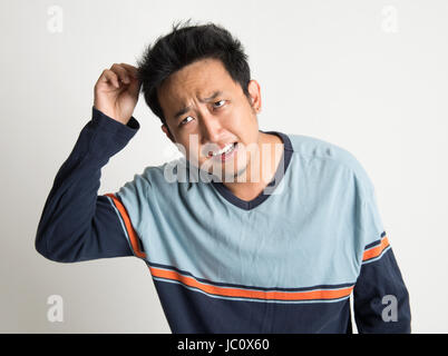 Asian man with bad hairstyle, sur fond uni Banque D'Images