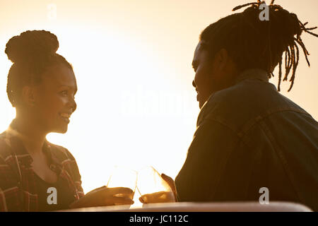 Silhouette d'un couple un toast pendant la golden hour Banque D'Images