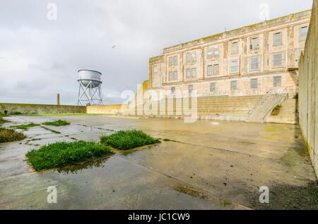 La cour de récréation sur l'île pénitencier d'Alcatraz, maintenant un musée, à San Francisco, Californie, USA. Une vue de la cour d'exercice, l'cellhouse et l'ancien château d'eau. Banque D'Images