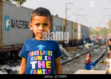 Portrait d'un enfant garçon dans park circus bidonville, un train passe à travers Banque D'Images