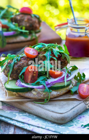 Agneau kofta de style turc avec salade de laitue roquette et houmus sur pain pitta Banque D'Images
