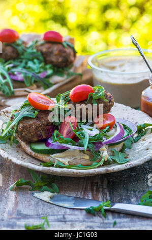 Agneau kofta de style turc avec salade de laitue roquette et houmus sur pain pitta Banque D'Images