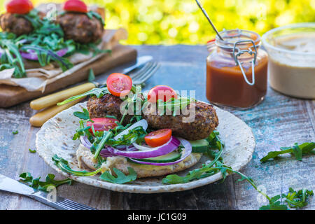 Agneau kofta de style turc avec salade de laitue roquette et houmus sur pain pitta Banque D'Images