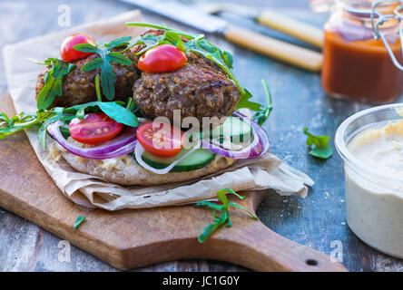 Agneau kofta de style turc avec salade de laitue roquette et houmus sur pain pitta Banque D'Images