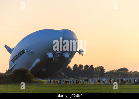 Cardington, Bedfordshire, Royaume-Uni. 13 Juin, 2017. L'HYBRIDE Véhicules Air Airlander 10 poursuit son programme d'essais en vol 2017. Décoller le temps sec dans le calme, avec du soleil et peu de nuages à Cardington Airfield il fait de grands circuits de la campagne locale avec trois touch and go passe à l'aire de mouillage avant de finalement l'atterrissage au crépuscule. Les décoller avec foule ci-dessous. Crédit photo : Mick Flynn/Alamy Live News Banque D'Images