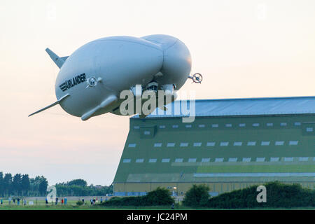 Cardington, Bedfordshire, Royaume-Uni. 13 Juin, 2017. L'HYBRIDE Véhicules Air Airlander 10 poursuit son programme d'essais en vol 2017. Décoller le temps sec dans le calme, avec du soleil et peu de nuages à Cardington Airfield il fait de grands circuits de la campagne locale avec trois touch and go passe à l'aire de mouillage avant de finalement l'atterrissage au crépuscule. Montée avec le dirigeable géant dans les hangars de l'arrière-plan. Crédit photo : Mick Flynn/Alamy Live News Banque D'Images