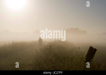 Suffolk Aldeburgh, UK. 14 Juin, 2017. Un marcheur est enveloppé dans un beau brouillard tôt le matin qu'elle est brûlée par le soleil au cours de l'estuaire de la rivière Alde à Aldeburgh sur la côte du Suffolk . Beau temps chaud devrait se répandre à travers la Grande-Bretagne à nouveau dans les prochains jours avec des températures atteignant jusqu'à 28 degrés dans certaines régions Crédit : Simon Dack/Alamy Live News Banque D'Images