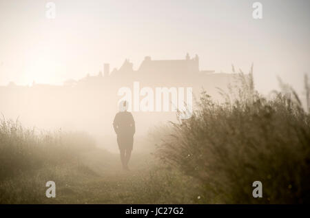 Suffolk Aldeburgh, UK. 14 Juin, 2017. Un marcheur est enveloppé dans un beau brouillard tôt le matin qu'elle est brûlée par le soleil au cours de l'estuaire de la rivière Alde à Aldeburgh sur la côte du Suffolk . Beau temps chaud devrait se répandre à travers la Grande-Bretagne à nouveau dans les prochains jours avec des températures atteignant jusqu'à 28 degrés dans certaines régions Crédit : Simon Dack/Alamy Live News Banque D'Images