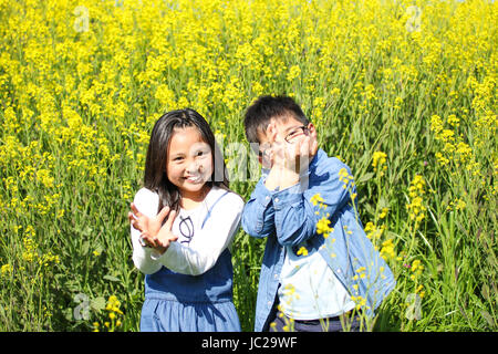 Les enfants dans le champ de moutarde Banque D'Images