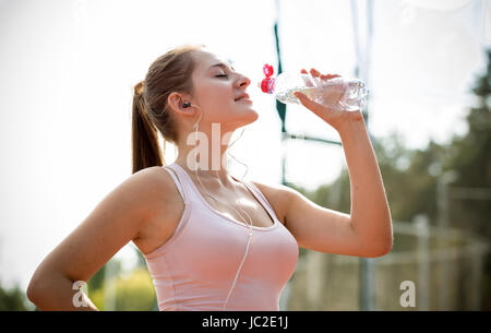 Closeup portrait of young woman having slim casser à l'exécution et de l'eau potable Banque D'Images