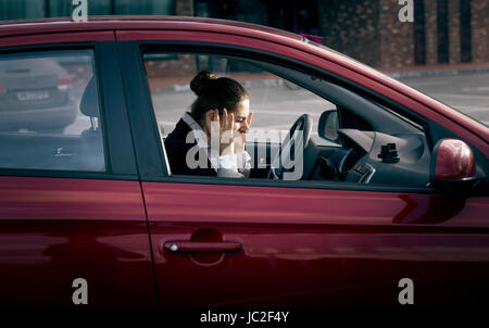 Young businesswoman sitting in car et crier de peur Banque D'Images