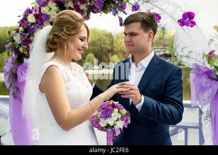 Portrait of handsome smiling toiletter anneau mettant la main sur brides Banque D'Images