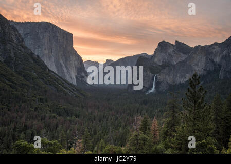 Scène de vue de tunnel dans la région de Yosemite National Park montrant un ciel teinté rouge sur la vallée Yosemite Banque D'Images