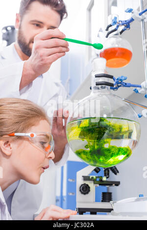 Le professeur et l'étudiant de faire des scientifiques en blouse blanche de laboratoire dans l'expérience Banque D'Images