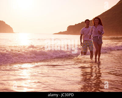 Happy young asian woman on beach in pendant le coucher du soleil ou le lever du soleil. Banque D'Images