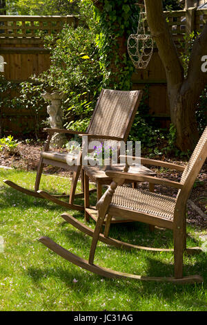 L'osier en bois chaises à bascule en ombragé jardin anglais Banque D'Images