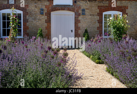 Chemin de gravier avec les pensionnaires de l'été des fleurs dans un jardin anglais Banque D'Images