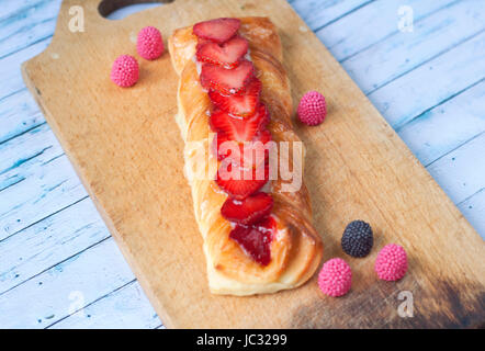 Dessert avec des fraises et de petits fruits bonbons sur une planche en bois Banque D'Images