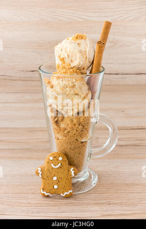 Boules de glaces et d'épice maison Gingerbread chapelure dans une latte de verre. Décorées avec un bâton de cannelle et un Gingerbread man. Banque D'Images