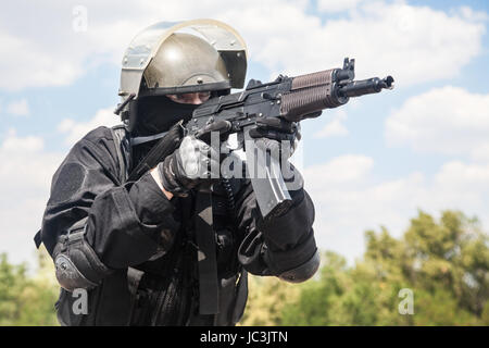 Spec Ops soldat en uniforme noir et masque de visage avec son fusil Banque D'Images