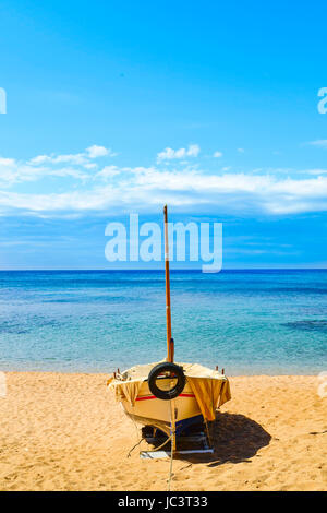 Un vieux bateau de pêche échoué dans la calme plage Platja de Sa Caleta à Lloret de Mar, sur la Costa Brava, Espagne Banque D'Images