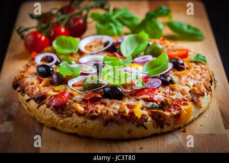 Des pizzas traditionnelles avec tomates, olives et basilic Banque D'Images