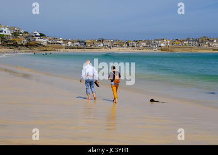 Personnes âgées en train de marcher le long de la plage de Porthminster à St Ives, Cornwall Banque D'Images