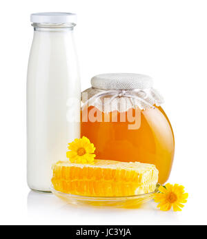 Miel doux dans des bocaux en verre avec des fleurs, d'abeilles et bouteille de lait isolated on white Banque D'Images