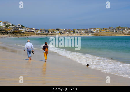 Personnes âgées en train de marcher le long de la plage de Porthminster à St Ives, Cornwall Banque D'Images