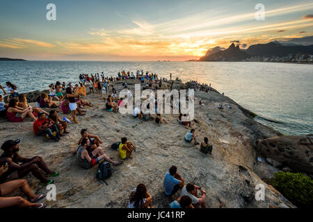 Les habitants et les touristes à regarder le coucher du soleil à partir de la plage de l'Arpoador Rock à Ipanema, Rio de Janeiro, Brésil Banque D'Images