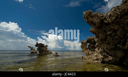 La mise en miroir des affleurements de corail dans les nuages d'Aldabra Cosmoledo, îles Seychelles Banque D'Images