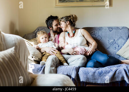 Les jeunes parents sur table avec leurs petits enfants Banque D'Images