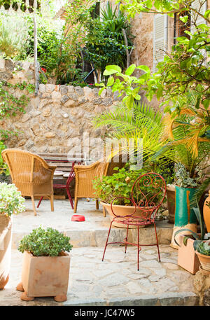 Cour traditionnelle avec des chaises et un lot o Fleurs dans vieux village dans l'île de Majorque, Espagne Banque D'Images