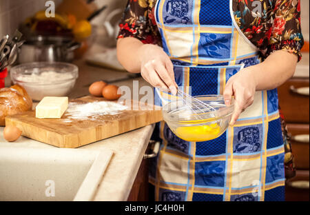 Photo gros plan de la femme en fouettant les oeufs dans un bol en verre Banque D'Images