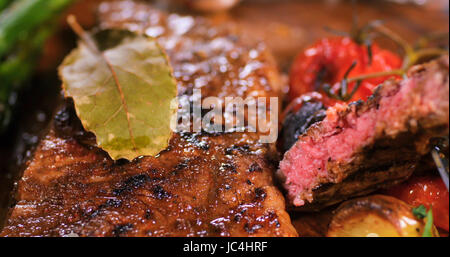 Extreme close up view d'un délicieux steak de surlonge aux asperges, Pommes de terre et tomates rôties Banque D'Images