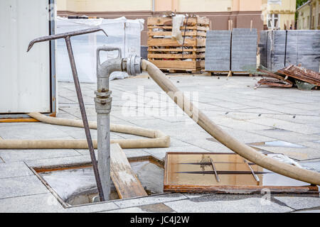 Vue sur l'eau assemblé le flexible à la prise d'incendie sur le chantier de construction. Banque D'Images