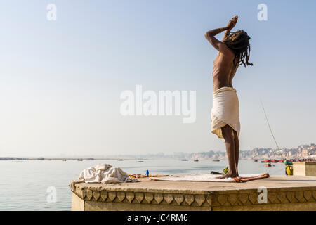 Un sadhu, saint homme, est debout et priant sur une plate-forme à la sainte gange à meer ghat à la banlieue, godowlia Banque D'Images