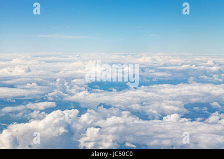 Au-dessus de l'horizon des nuages blancs dans le ciel bleu et les terres sous les nuages Banque D'Images